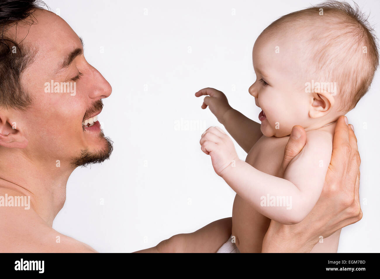 Vater hält ein Baby und lachend auf weißem Hintergrund Stockfoto