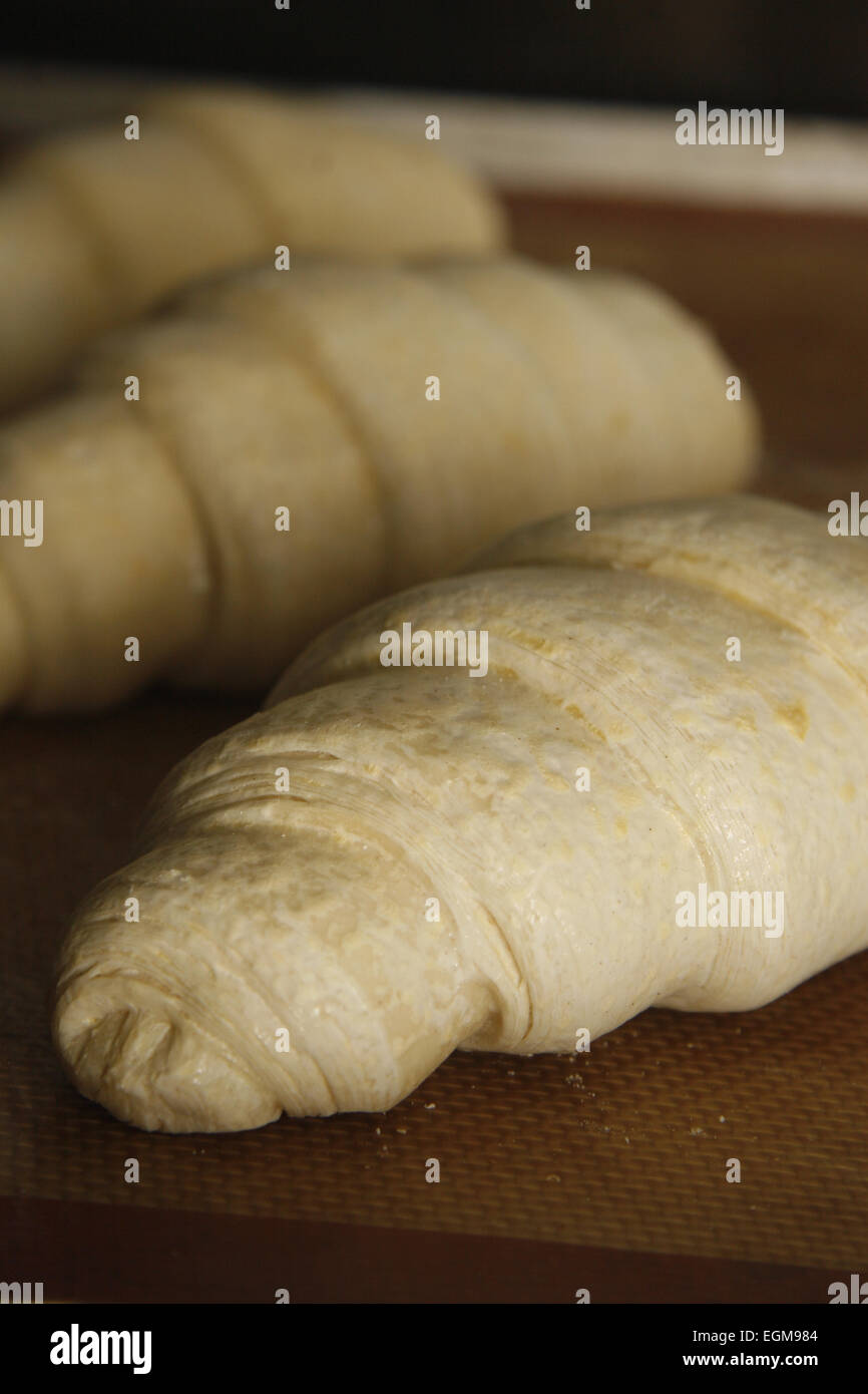ungekocht Croissants auf ein Backblech Matte im Ofen einsatzbereit Stockfoto