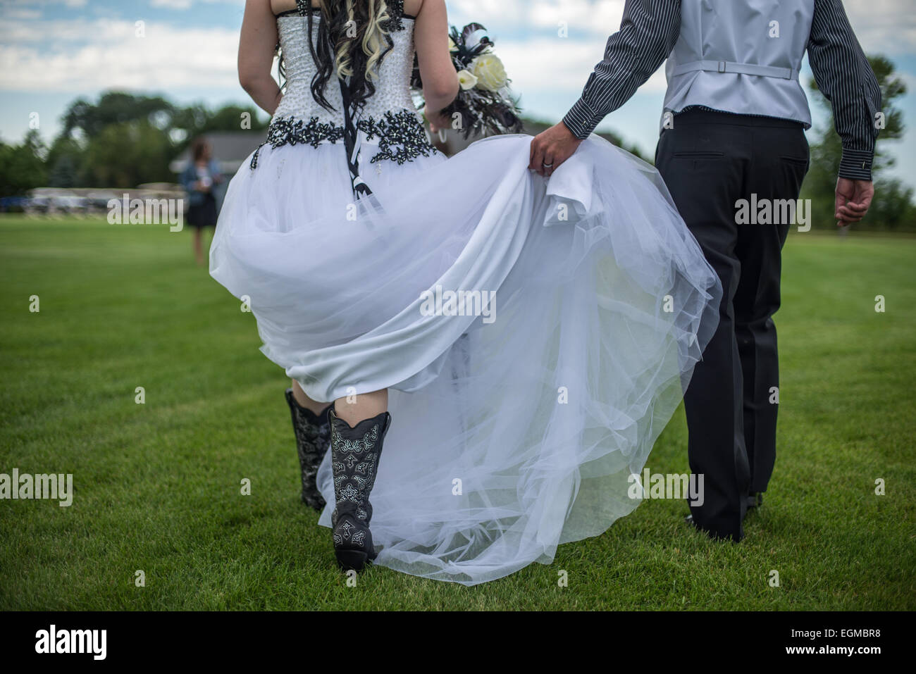 Eine Braut und Bräutigam zu Fuß in der Sommer-Rasen. Stockfoto