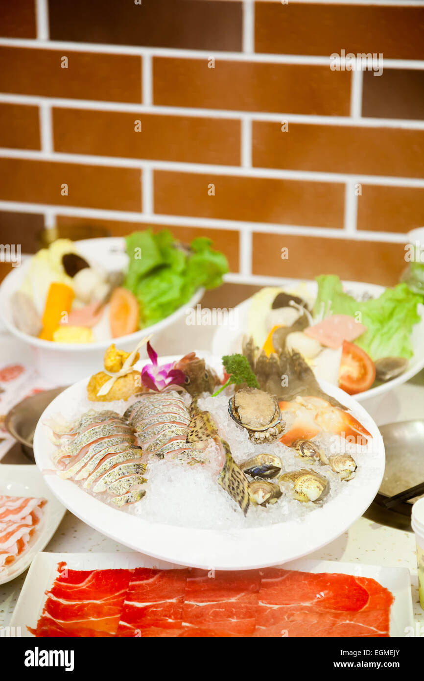 Die chinesische hot pot Essen eingestellt - Meeresfrüchte und Fleisch auf dem Tisch in einem Restaurant Stockfoto