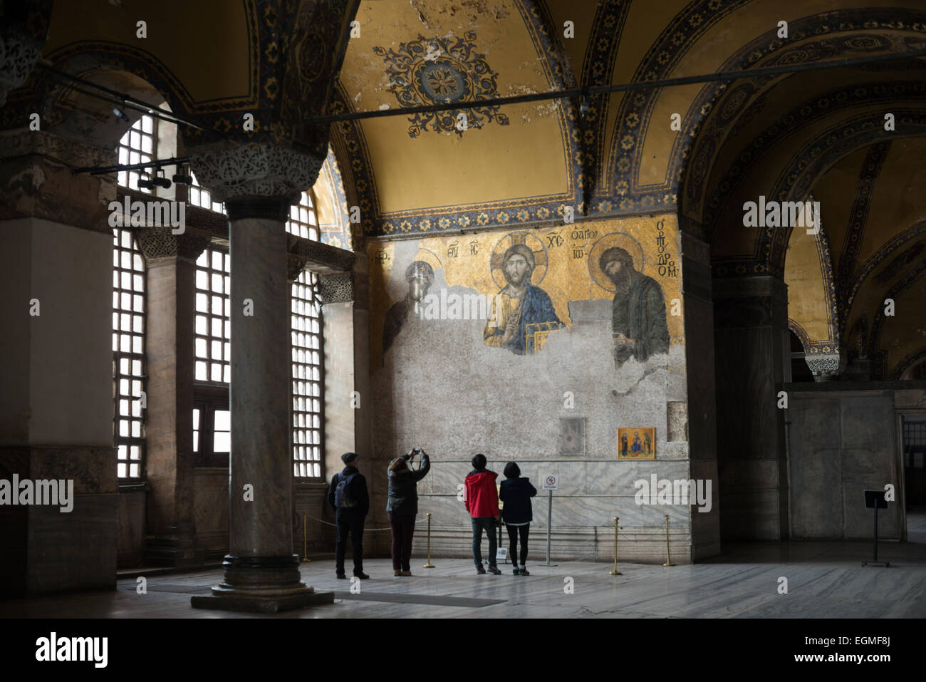 Hagia Sophia Deësis Mosaic Istanbul Türkei // ISTANBUL, Türkei — das berühmte Deësis Mosaik in der oberen Galerie der Hagia Sophia stammt aus dem Jahr 1261. Dieses byzantinische Meisterwerk zeigt Christus Pantokrator flankiert von der Jungfrau Maria und Johannes dem Täufer in einem Dreiviertelprofil, was ihre Fürbitte für die Menschheit veranschaulicht. Das Mosaik stellt eines der schönsten erhaltenen Beispiele byzantinischer religiöser Kunst dar. Stockfoto