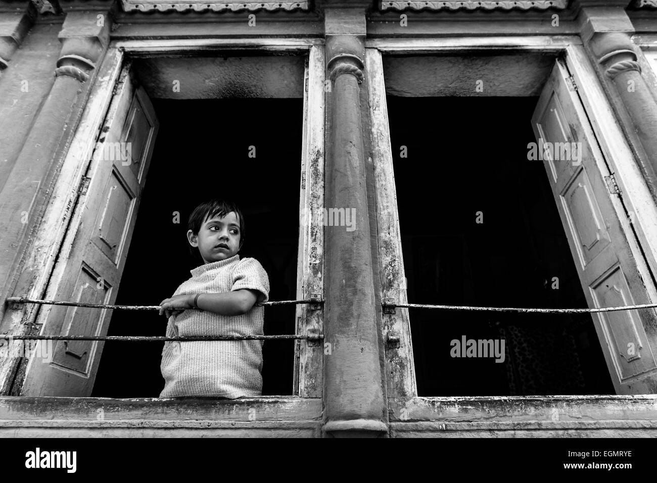 Ein Kind Uhren der Welt vorbeiziehen von seinem Haus mit Blick auf die Straße, Jodhpur, Indien Stockfoto