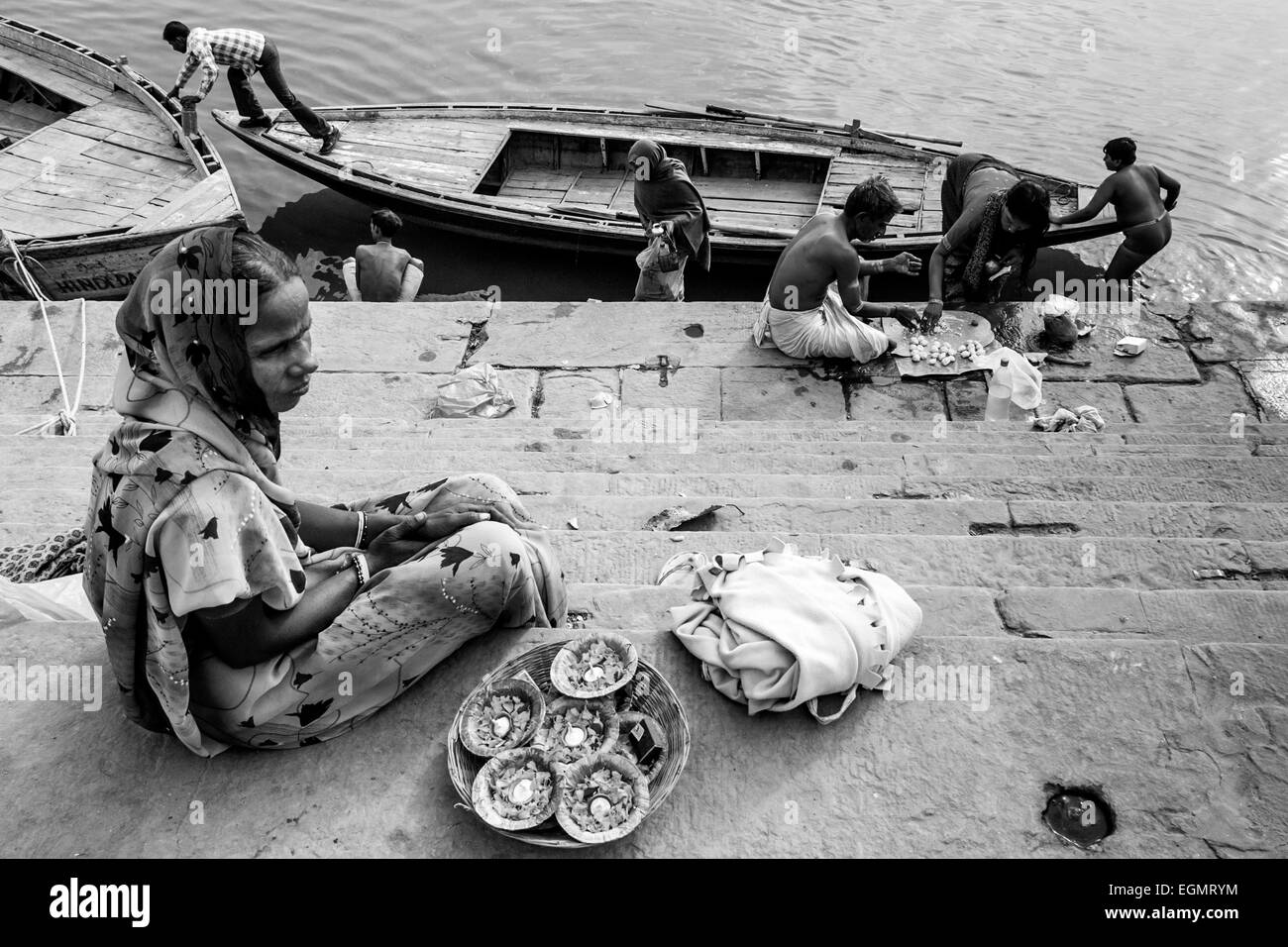 Blumenverkäuferin sitzen auf den Ghats, Varanasi, Uttar Pradesh, Indien Stockfoto