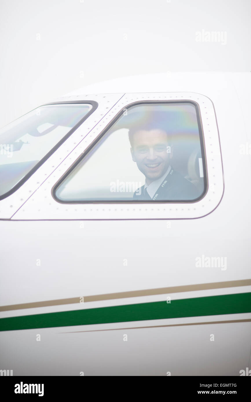 Mann im Cockpit eines Privatjets aus dem Piloten / Kapitäne Fenster und schauen glücklich, dort zu sein Stockfoto