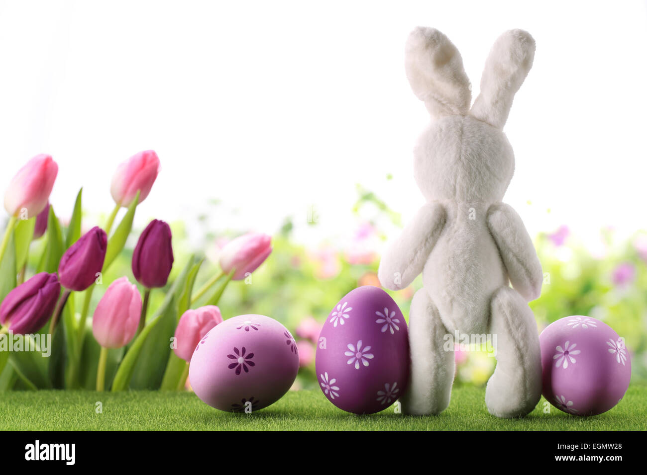 Oster-Deko mit Hasen, Eiern und Blumen. Stockfoto