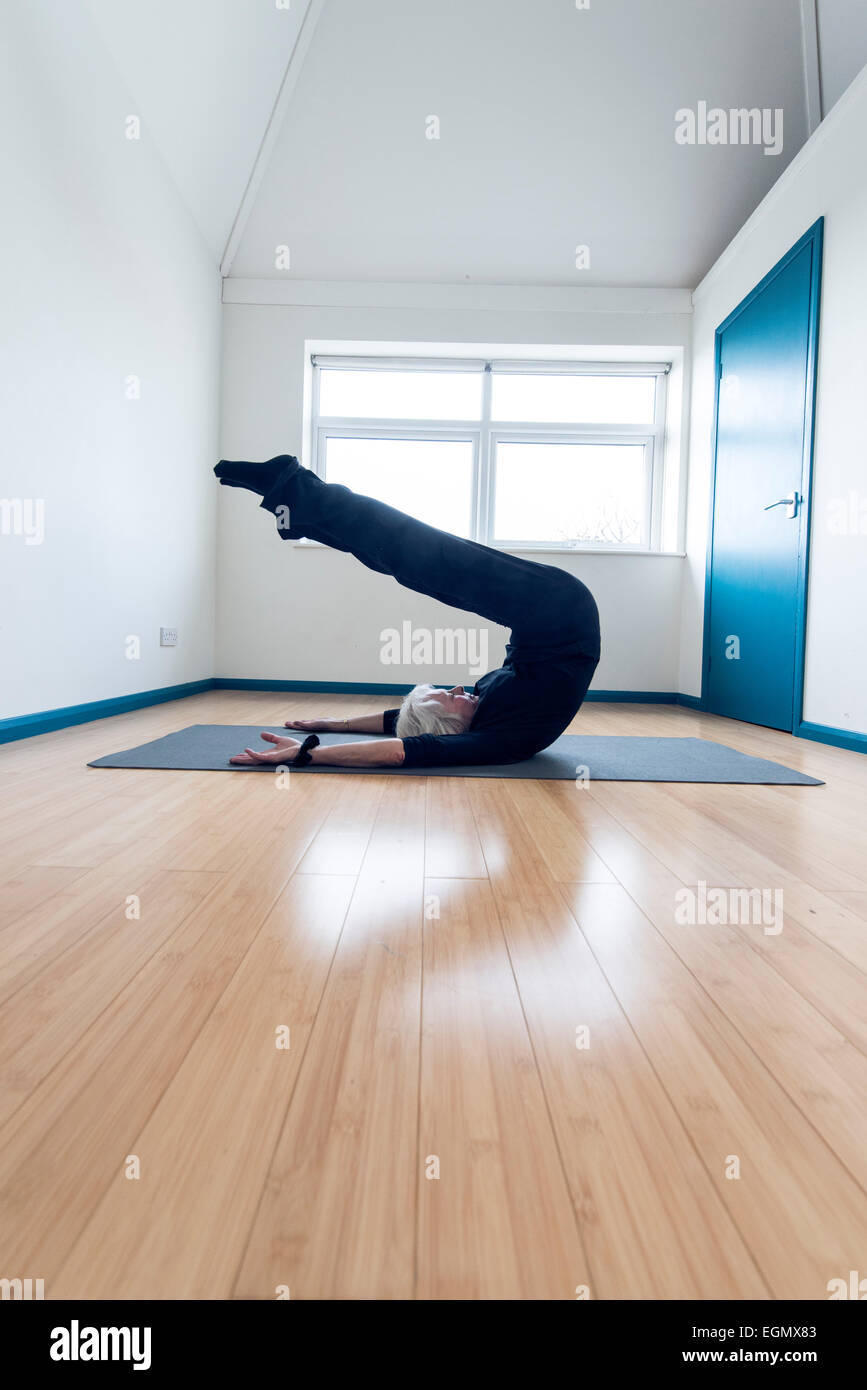ältere ältere Dame Gaumen Yoga zu praktizieren und dabei sehr flexibel in einigen ungewöhnlichen Positionen aktiv zu halten, Stockfoto