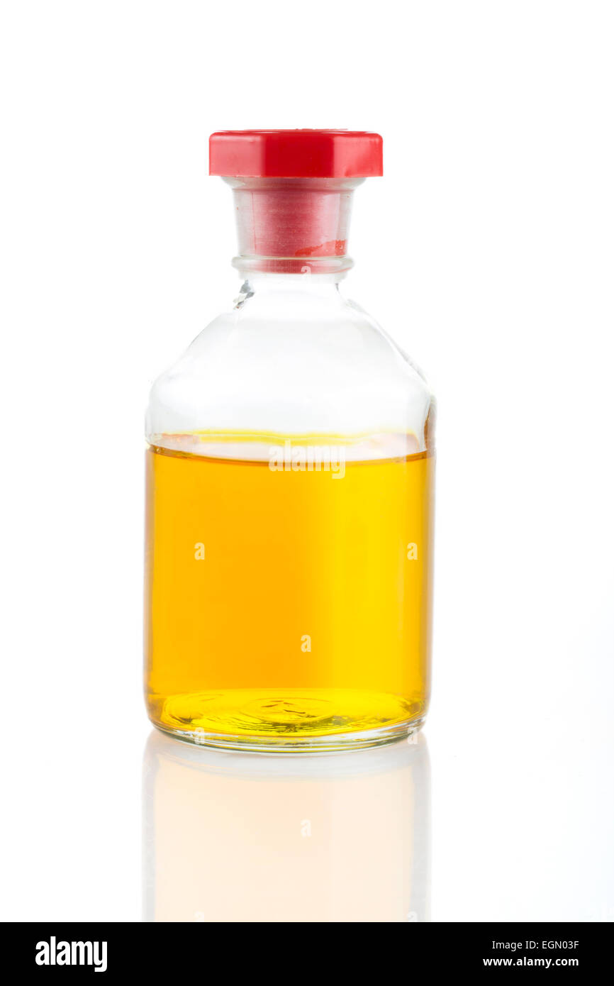 Durchsichtiger Glasflasche mit gelben Flüssigkeit und roten Stopfen. Stockfoto