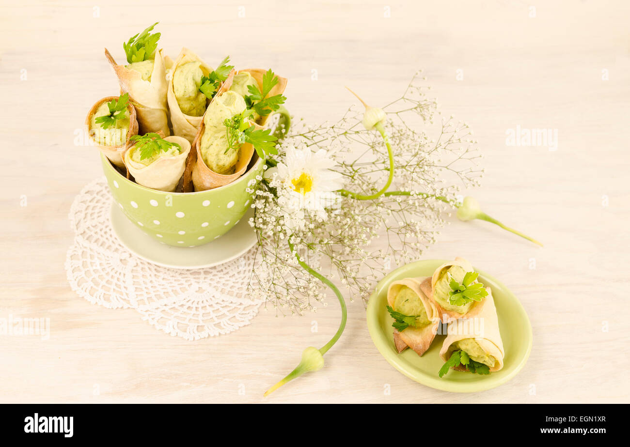 Herzhafte Cannoli mit Ricotta, Erbsen und Petersilie gefüllt. In der Nähe von schönen Blumenstrauß. Selektiven Fokus. Draufsicht. Aus einer Stockfoto