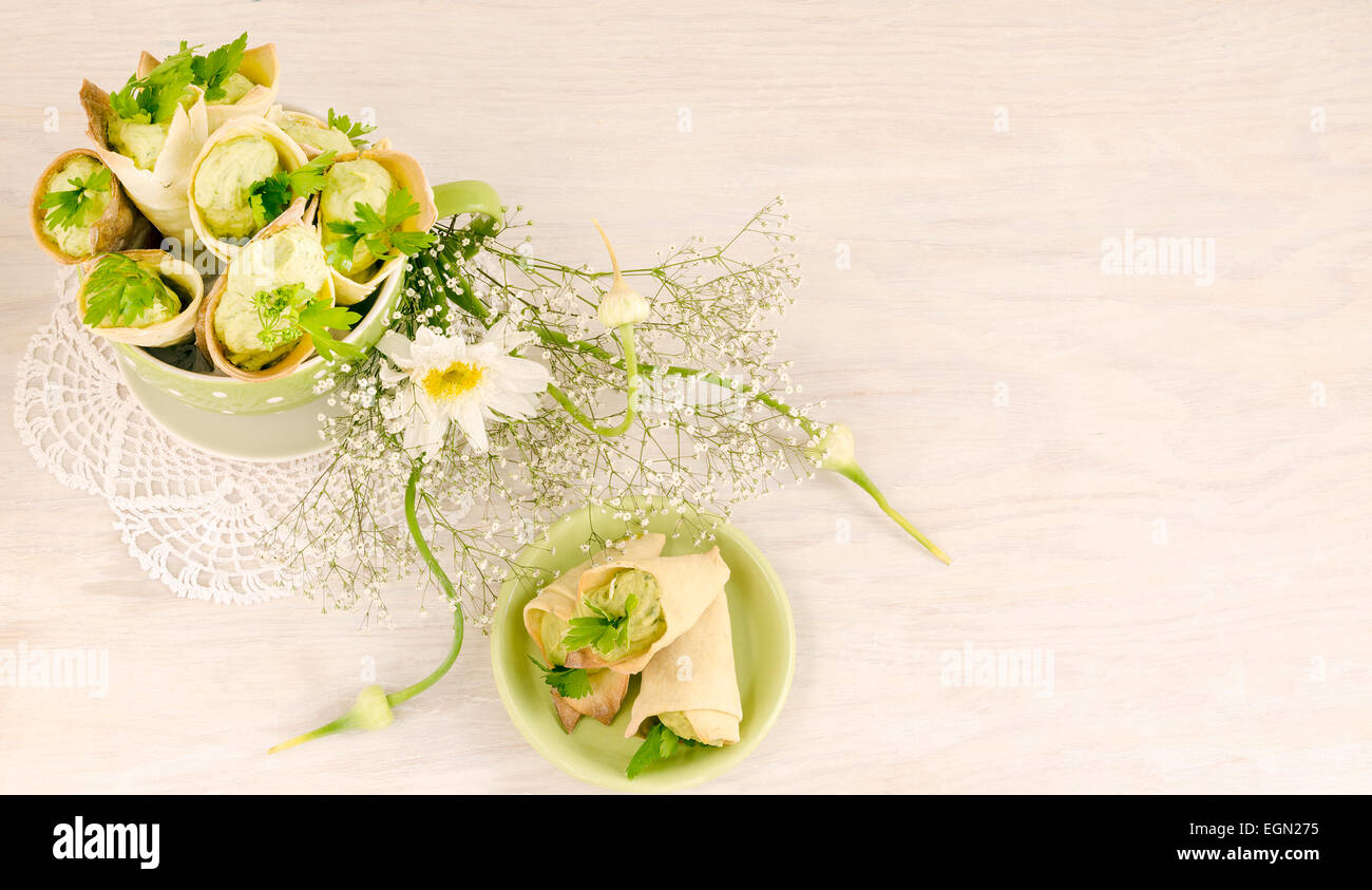 Herzhafte Cannoli mit Ricotta, Erbsen und Petersilie gefüllt. In der Nähe von schönen Blumenstrauß. Draufsicht. Aus einer Reihe von Italia Stockfoto