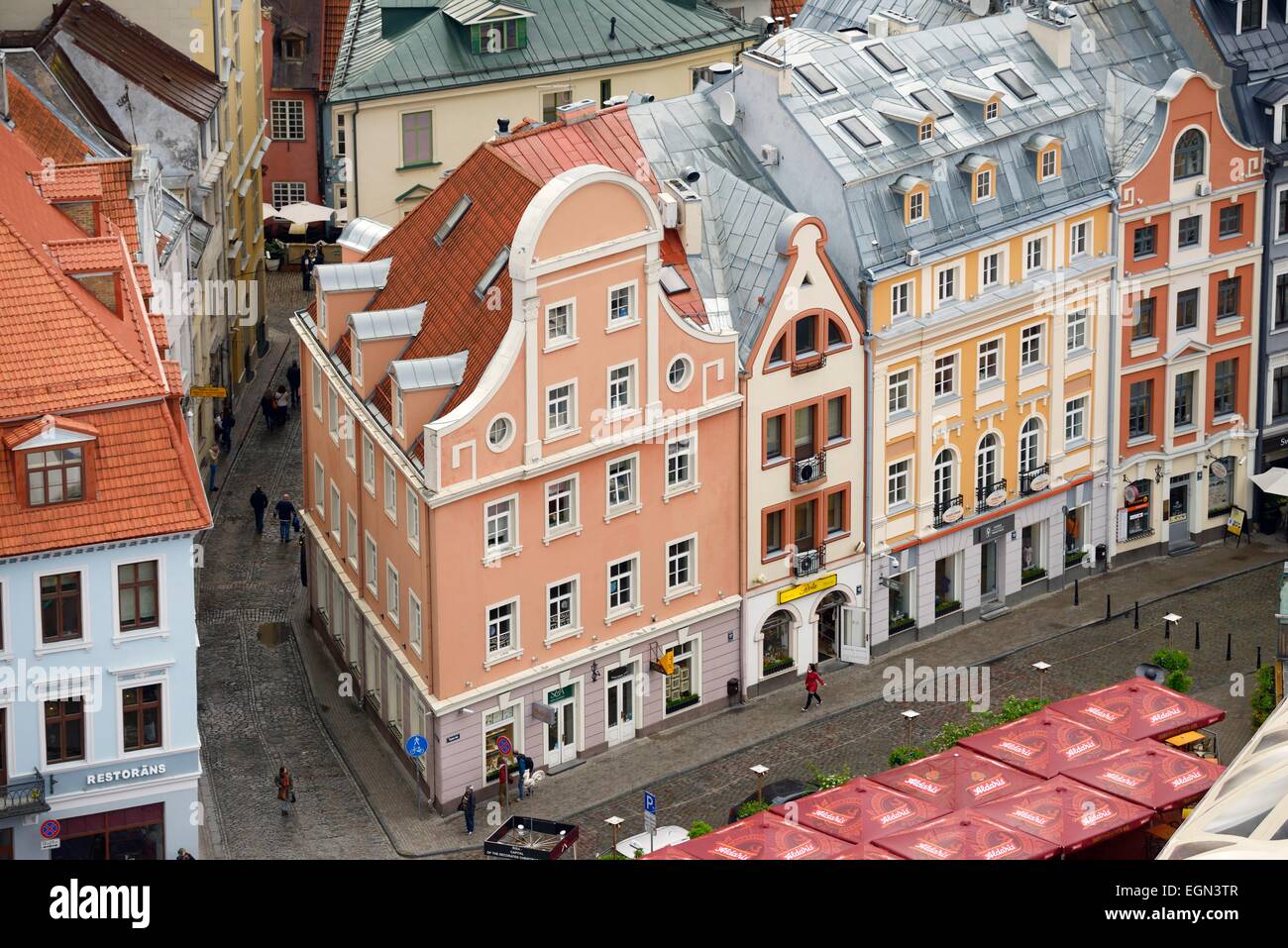 Riga, Lettland. Teil der alten Innenstadt zum UNESCO-Weltkulturerbe. Häuser auf Tirgonu Iela aus der Turm der St.-Petri Kirche Stockfoto