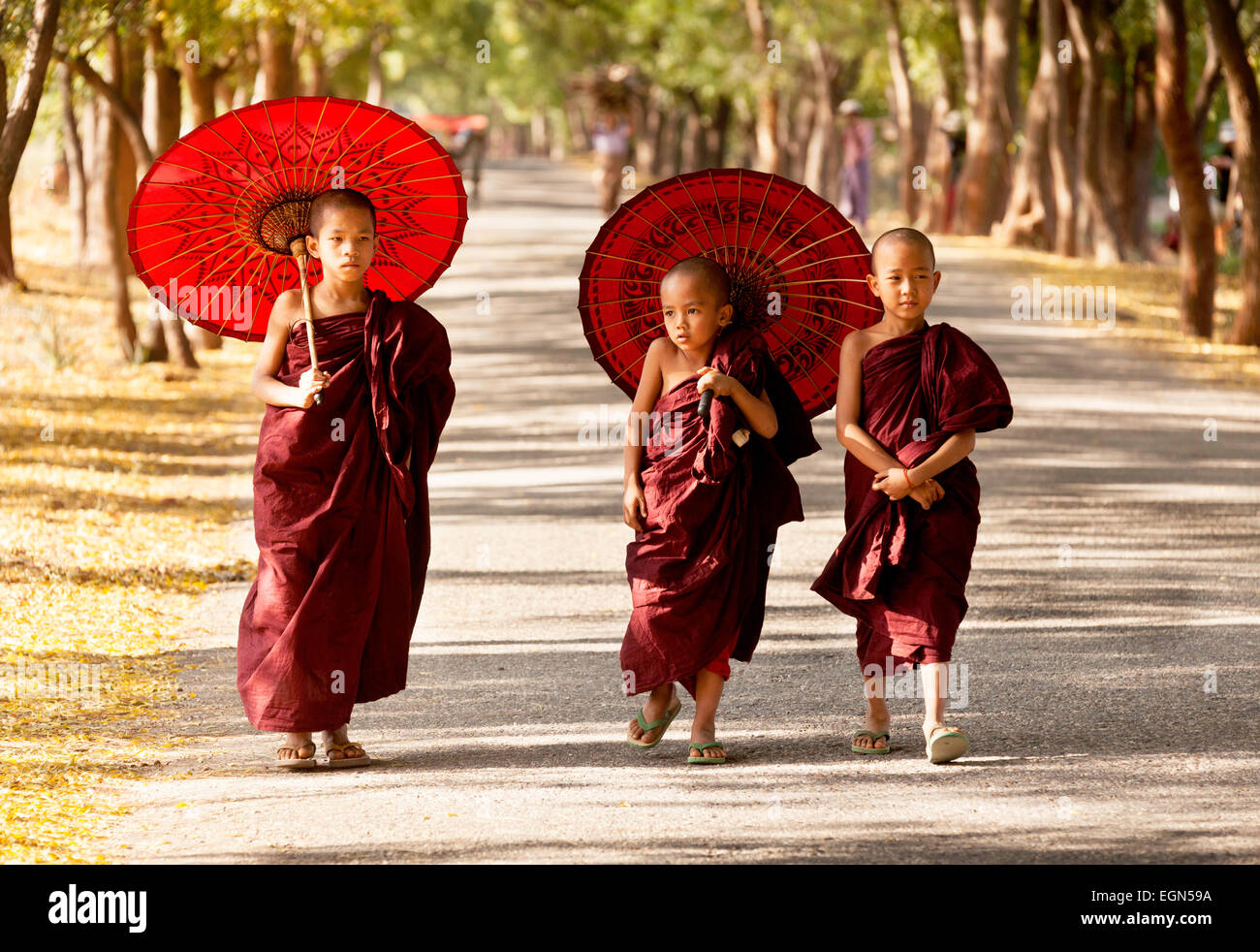 Drei junge buddhistische Mönche zu Fuß entlang einer Straße, Bagan, Myanmar (Burma), Asien Stockfoto