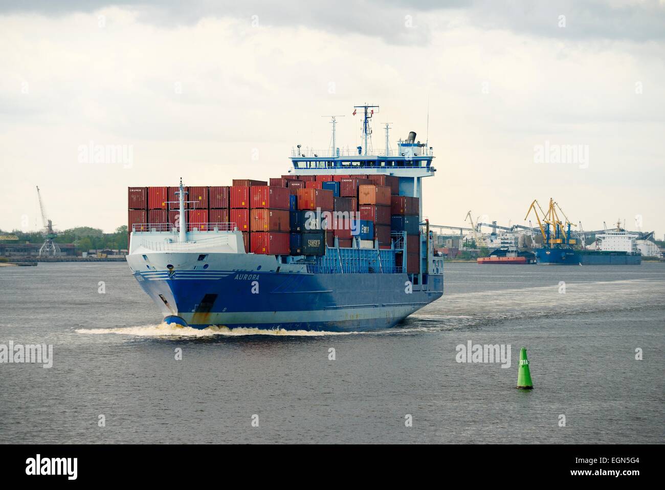 Riga Lettland. Kaufmann Frachtschiffahrt am Fluss Daugava im Freihafen von Riga. Containerschiff Schiff Aurora verlassen Hafen Stockfoto