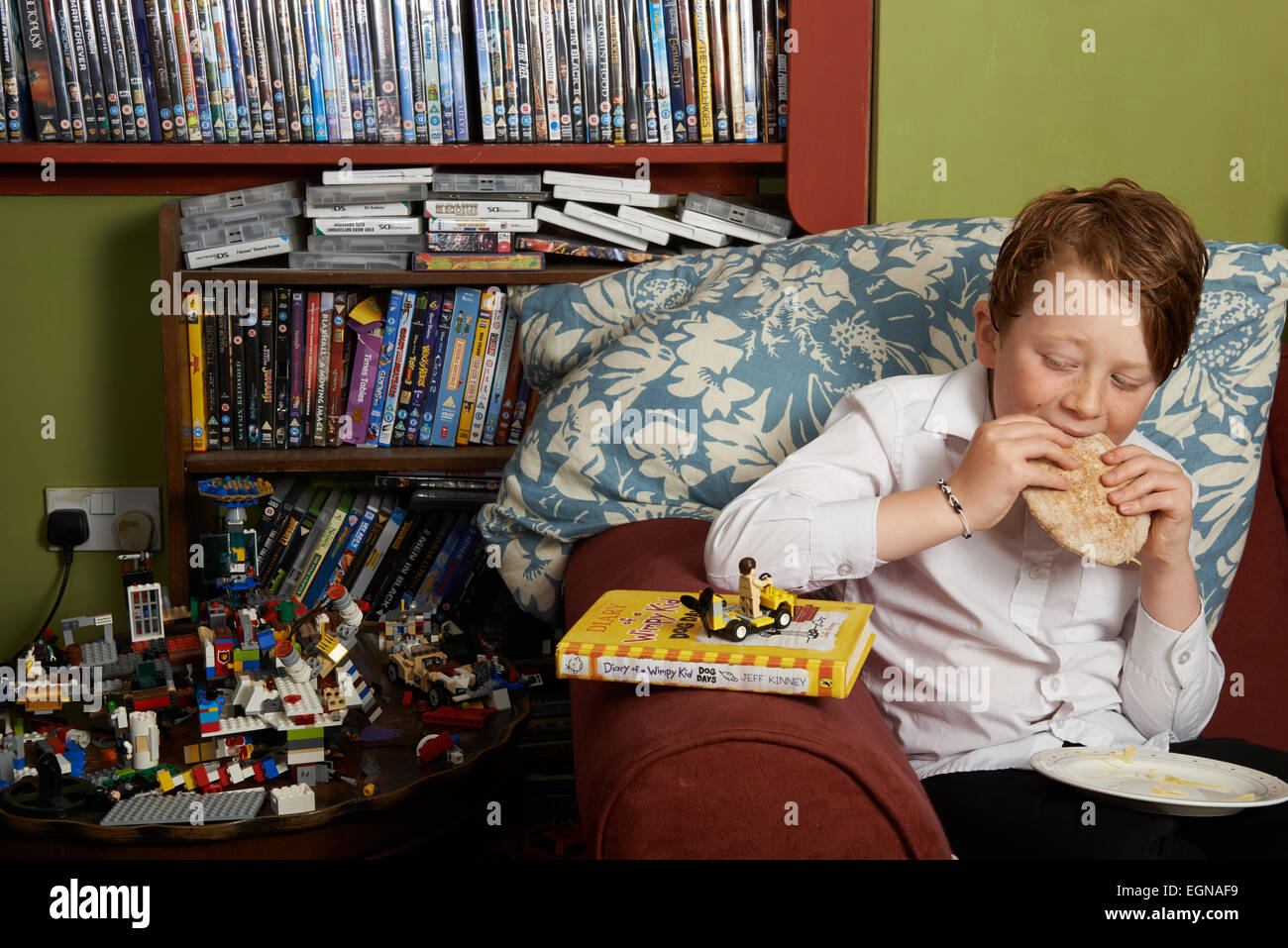 10 Jahre alten Jungen zu Hause nach der Schule ein Pitta Brot Sandwich zu essen Stockfoto