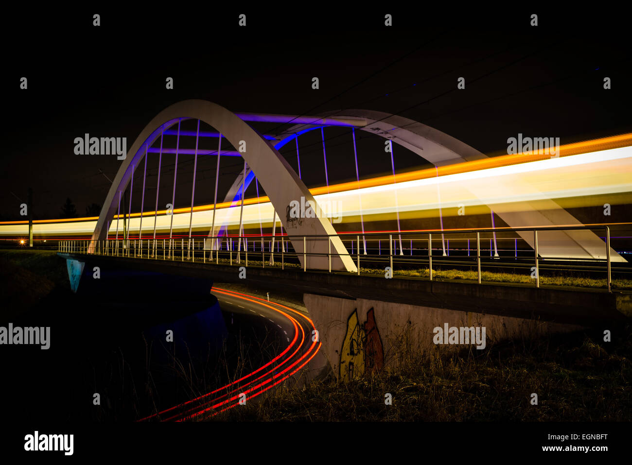 Eisenbahnbrücke mit Zug und Auto Lichter in der Nacht Stockfoto