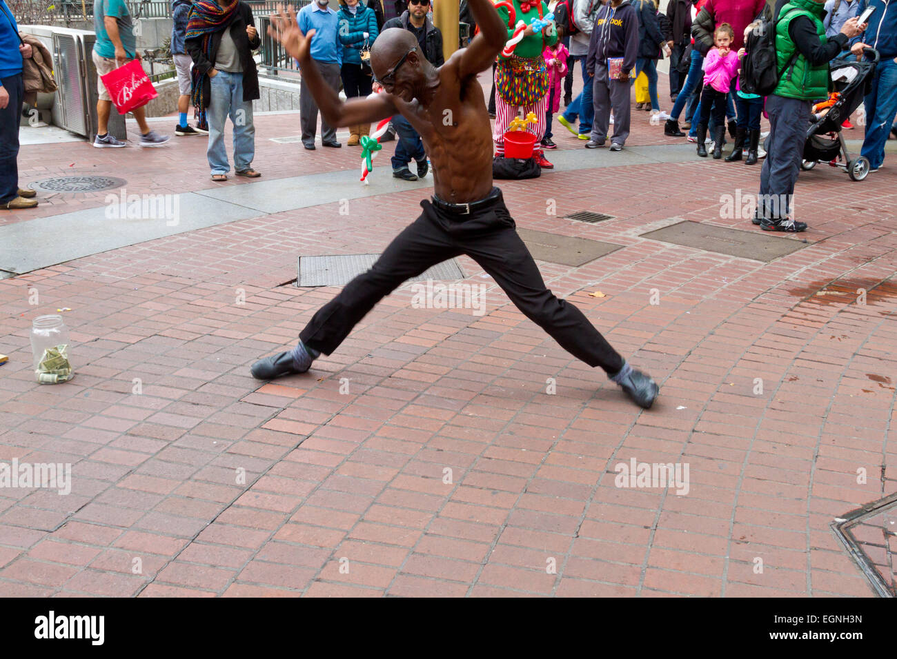 Eine sportliche, schwarze Straße Tänzerin führt für ein Publikum. Stockfoto
