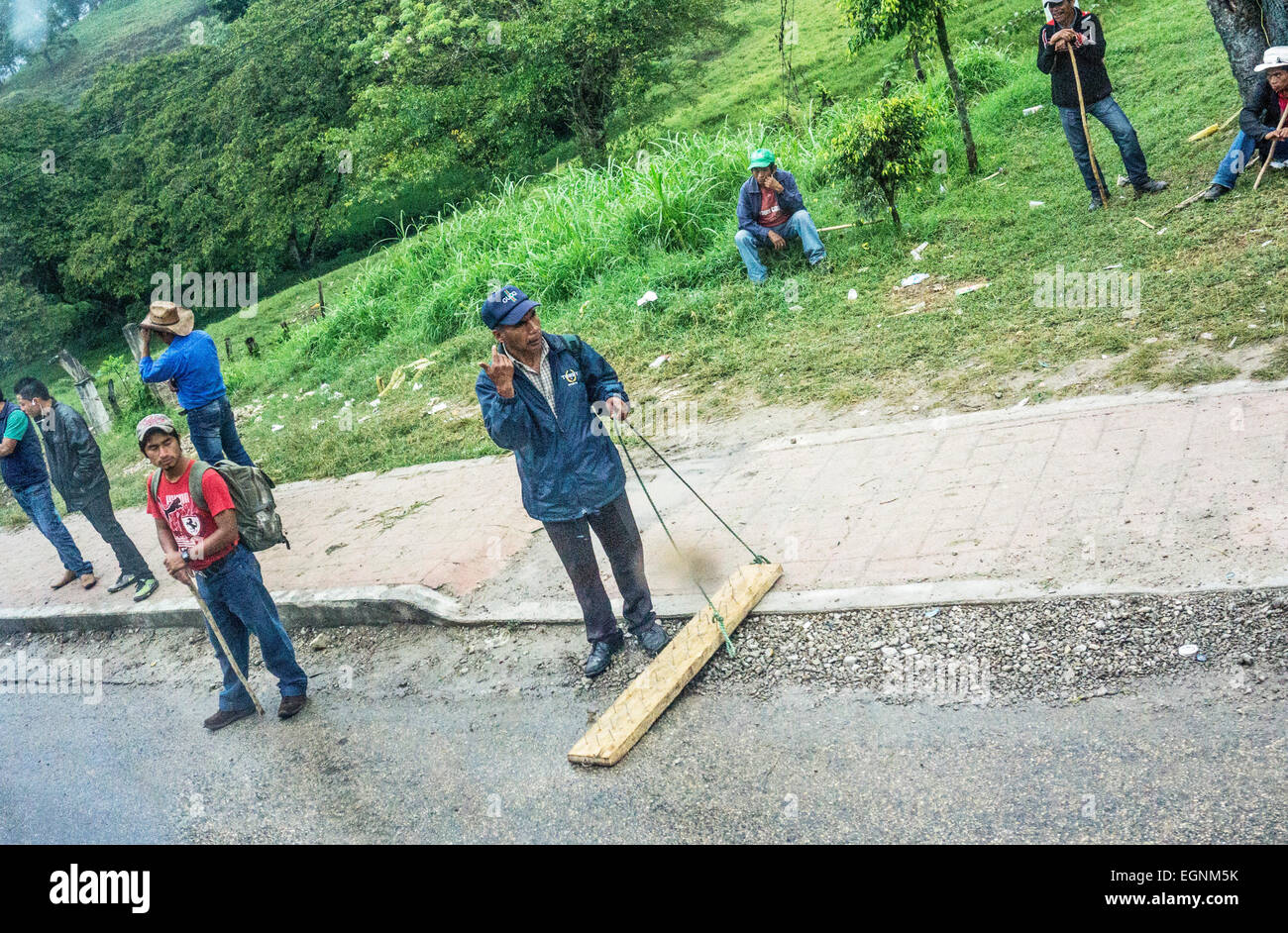 Ocosingo Chiapas, Mexiko. 27. Februar 2015. Fröhliche Bande von jungen Zapatisten richten Sie ein Holzbrett mit Nägeln nach oben, um Datenverkehr in beide Richtungen zu stoppen & höflich Busse, bitten um Spenden für ihre Sache oder bitten Autofahrer direkt an Bord. Dann sind die Nägel kurz zurückgezogen, um Fahrzeug übergeben zu ermöglichen. Abgesehen von den Nägeln, keine Gefahren bestehen Credit: Dorothy Alexander/Alamy Live News Stockfoto