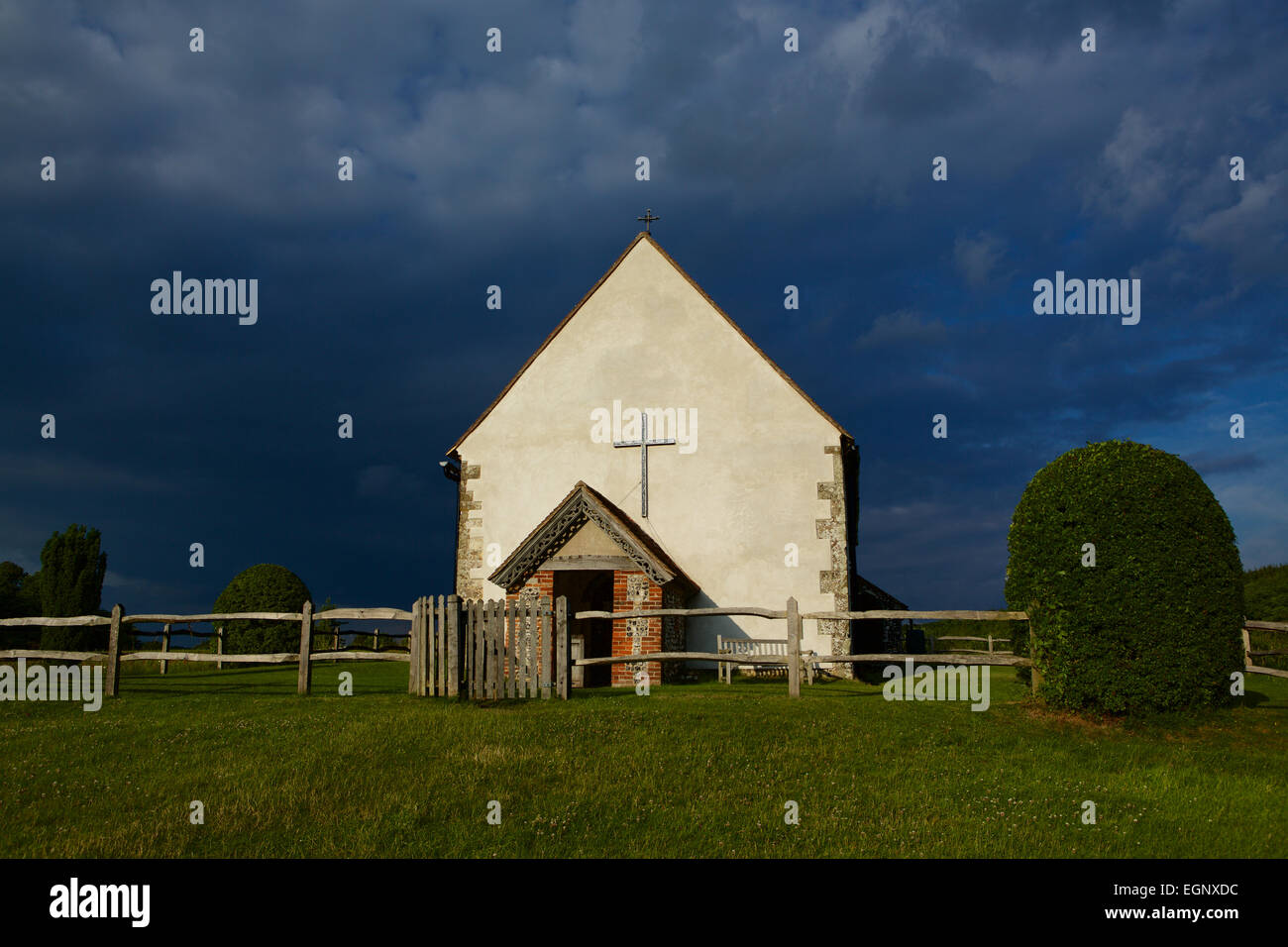 St. Huberts. Sehr dunkle Gewitterwolke Kontrast zu der weißen Kirche. Kirche im Feld Idsworth. Stockfoto