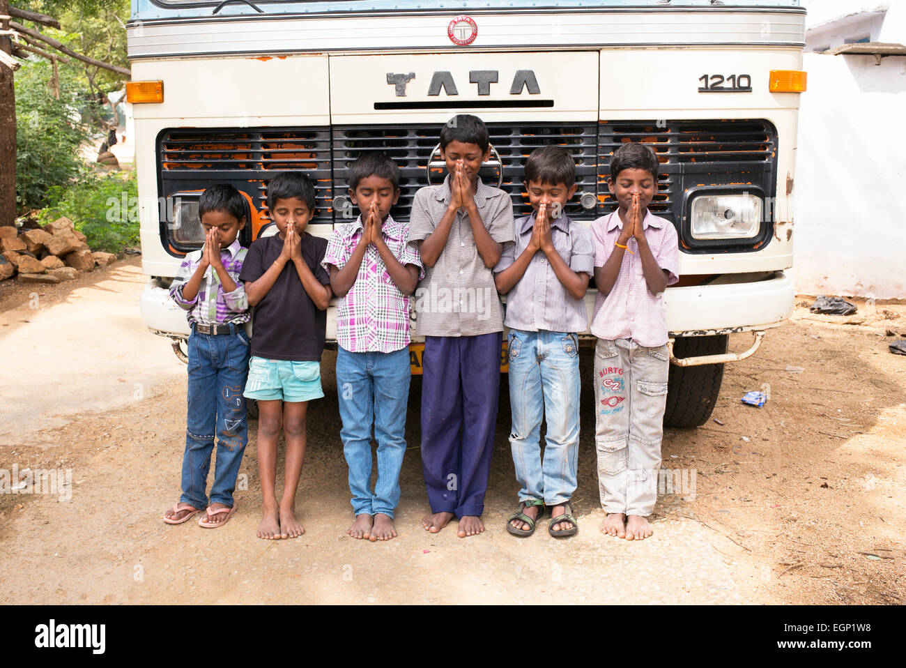 Linie der indischen Dorf Jungs vor ein Tata-Bus bietet Namaskar. Andhra Pradesh, Indien Stockfoto