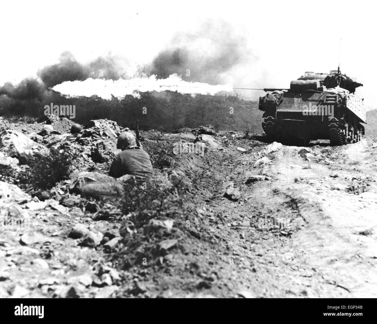 Schlacht von IWO JIMA Februar / März 1945. US-Flammenwerfer ausgerüstet Panzer in Aktion beobachtet von hockend Marines. Stockfoto