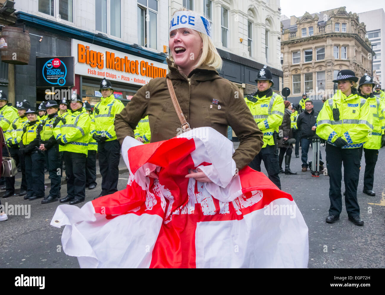 Eine Frau hält einen England-Flagge vor eine Polizeiabsperrung zu Pegida Protest in Newcastle Upon Tyne, England. UK Stockfoto