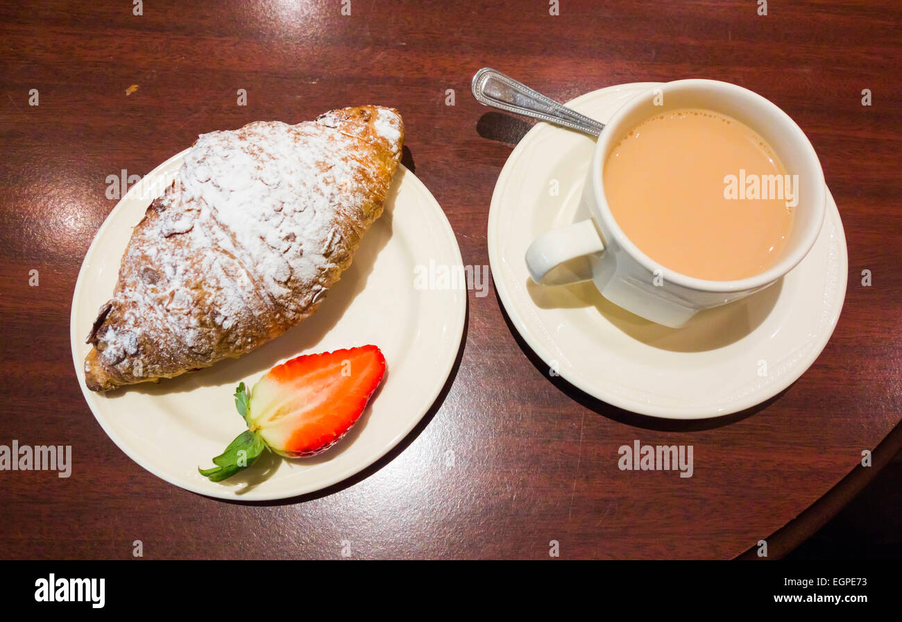 Nachmittagstee im Landhaus eine Tasse Tee und einem frisch gebackenen Mandel-Croissant Stockfoto