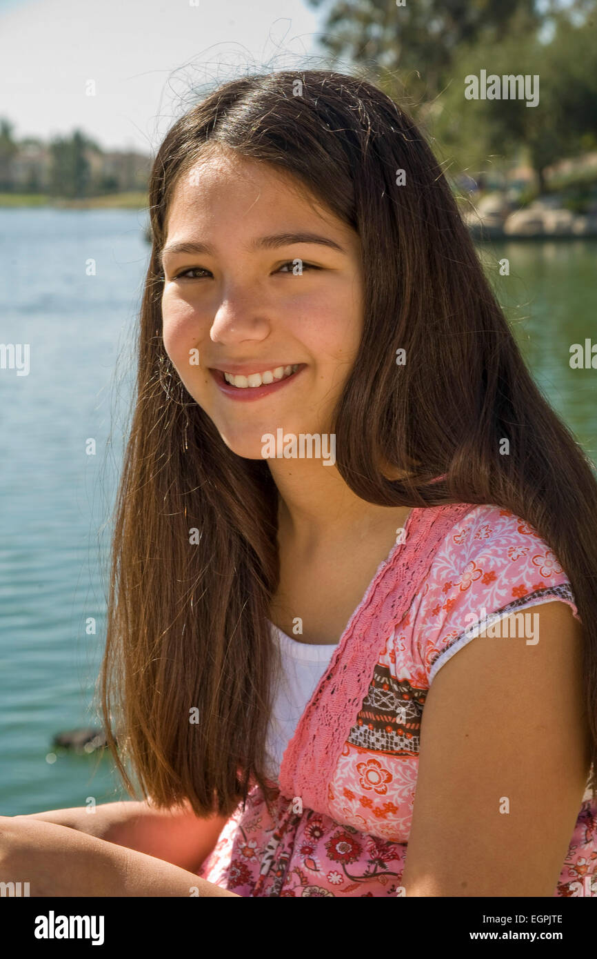 Hispanic-kaukasischen Teen Mädchen 11-13 jährige lächelnd Porträt im Park mit lake.mixed Rennen, rassische Mischung Vielfalt multikulturellen Herr © Myrleen Pearson Stockfoto