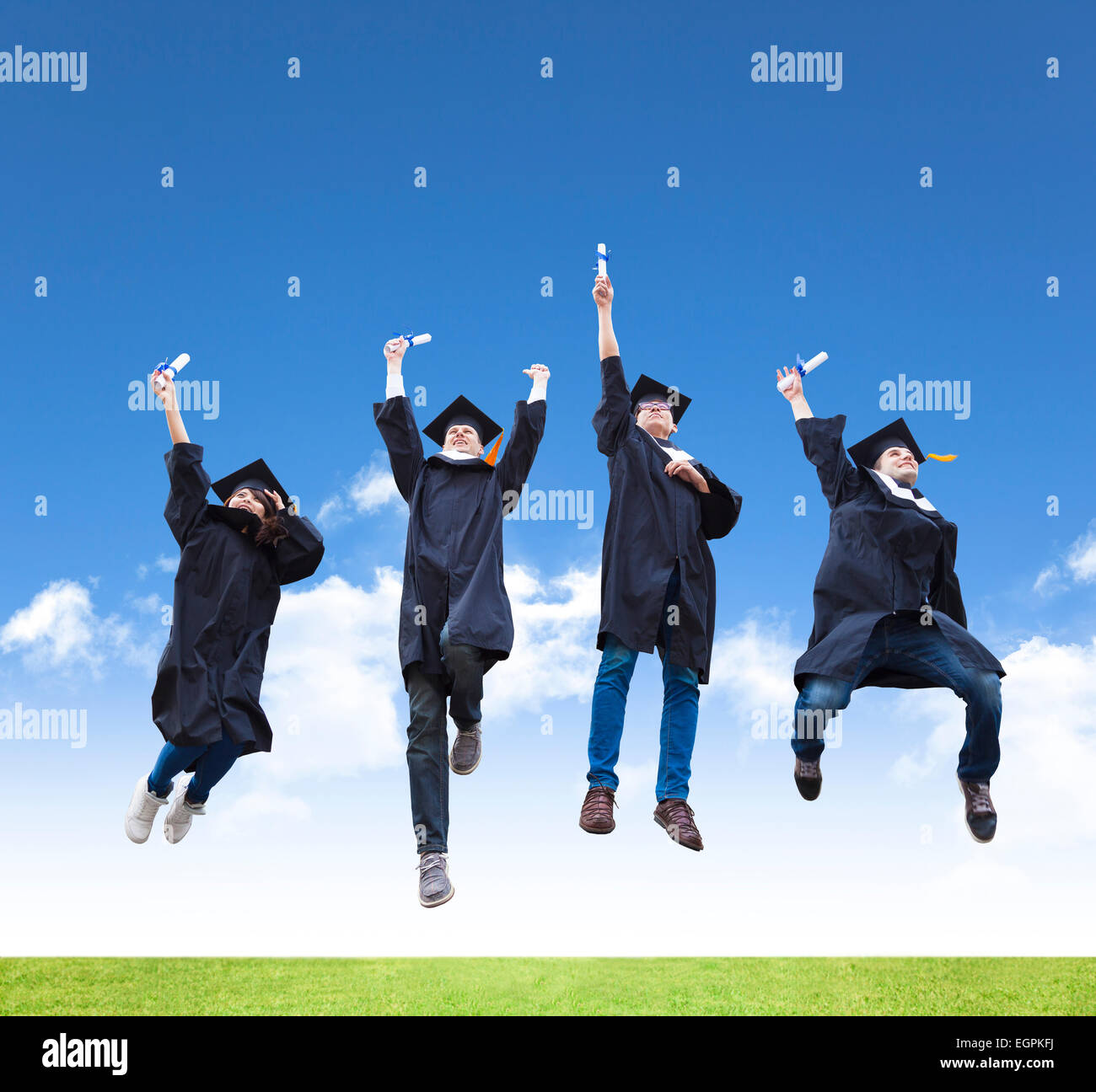Glückliche junge Gruppe von Abschluss-Schüler springen zusammen Stockfoto