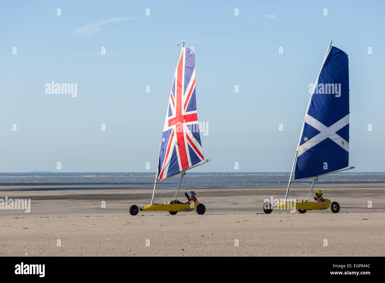 Zwei Yachten mit britischer Flagge Segel, das andere mit dem schottischen Andreaskreuz auf einen Strand landen Stockfoto