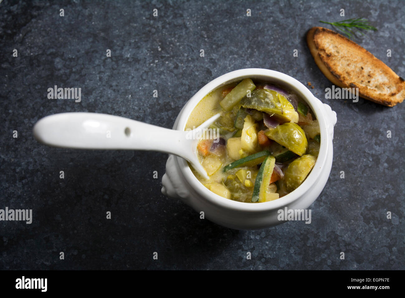 Gemüsesuppe in weiße Schüssel auf einem dunklen Hintergrund mit Textur Stockfoto