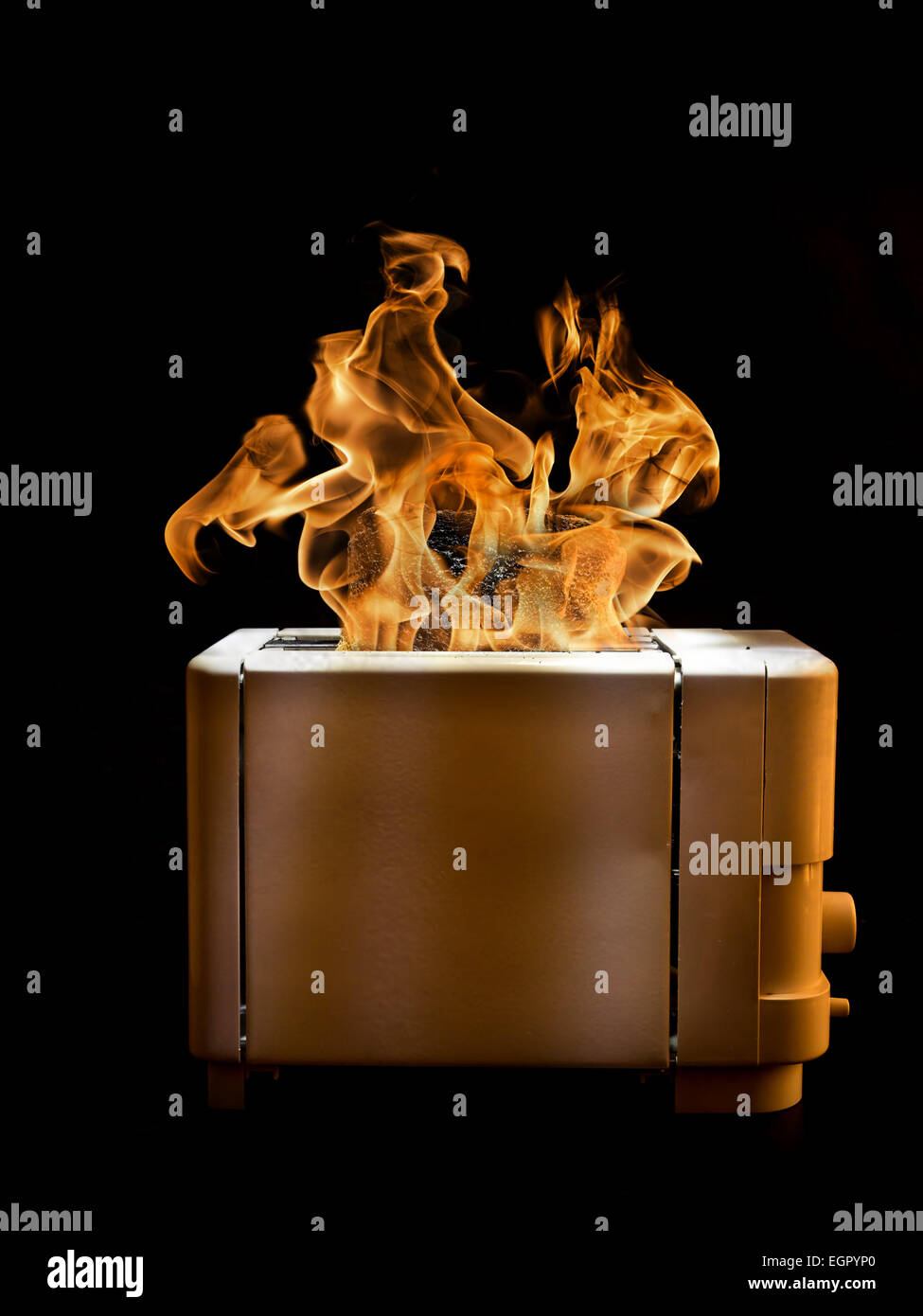 Toaster mit zwei Scheiben Toast auf schwarzem Hintergrund auf Feuer gefangen. Stockfoto