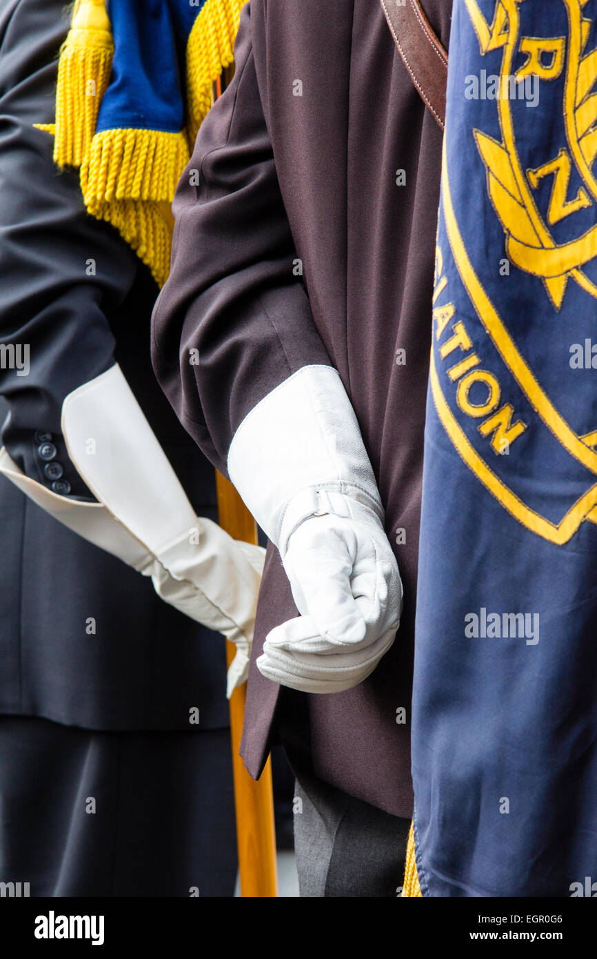 Nahaufnahme von Details einer weißen Hand mit Handschuhen, die während der Zeremonie „entspannt“ hinter dem Rücken eines Mannes in Militäruniform gehalten wird. Stockfoto