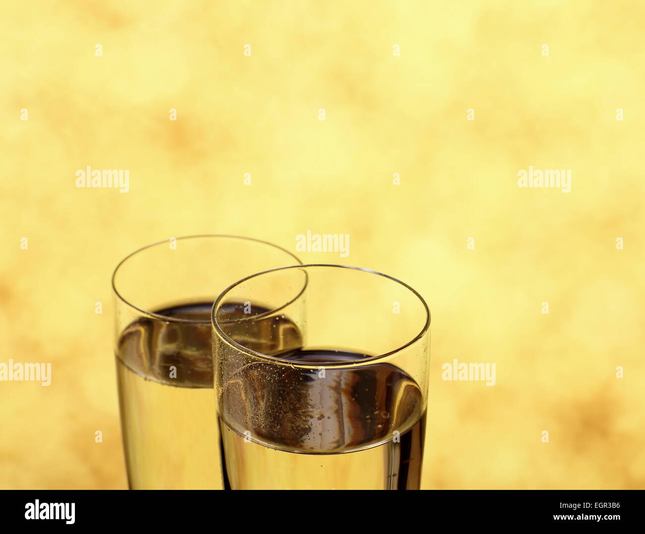 Zwei Gläser mit Champagner als Eheringe Symbol, der Hintergrund jedoch unscharf Stockfoto
