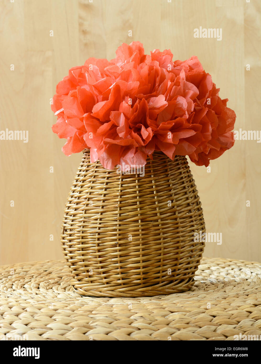 Vase-Korb mit rotem Seidenpapier Blume auf gewebte Oberfläche mit Holz Hintergrund Stockfoto