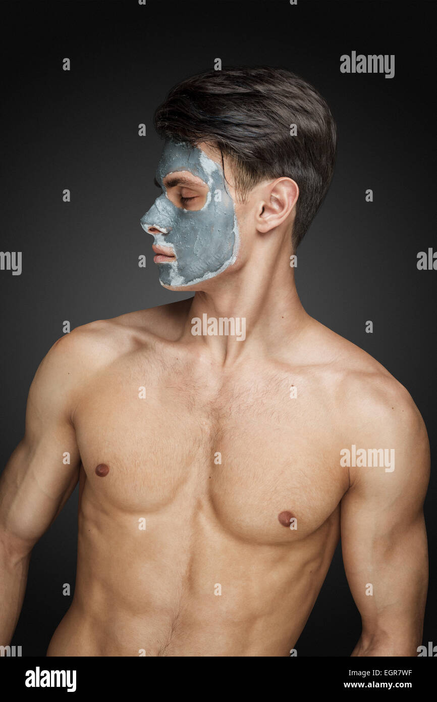 Porträt eines schönen jungen Mannes mit einer Gesichtsbehandlung Schlamm Lehm Maske, Gesicht und Körper Hautpflege. Stockfoto