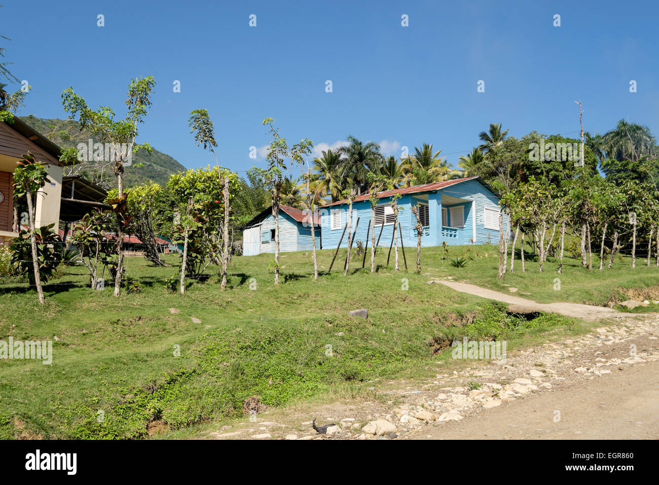 Ein typisches Holzhaus mit Wellpappe Blechdach und Nebengebäude zum Kochen in einem ländlichen Dorf. Dominikanische Republik, Caribbean Stockfoto