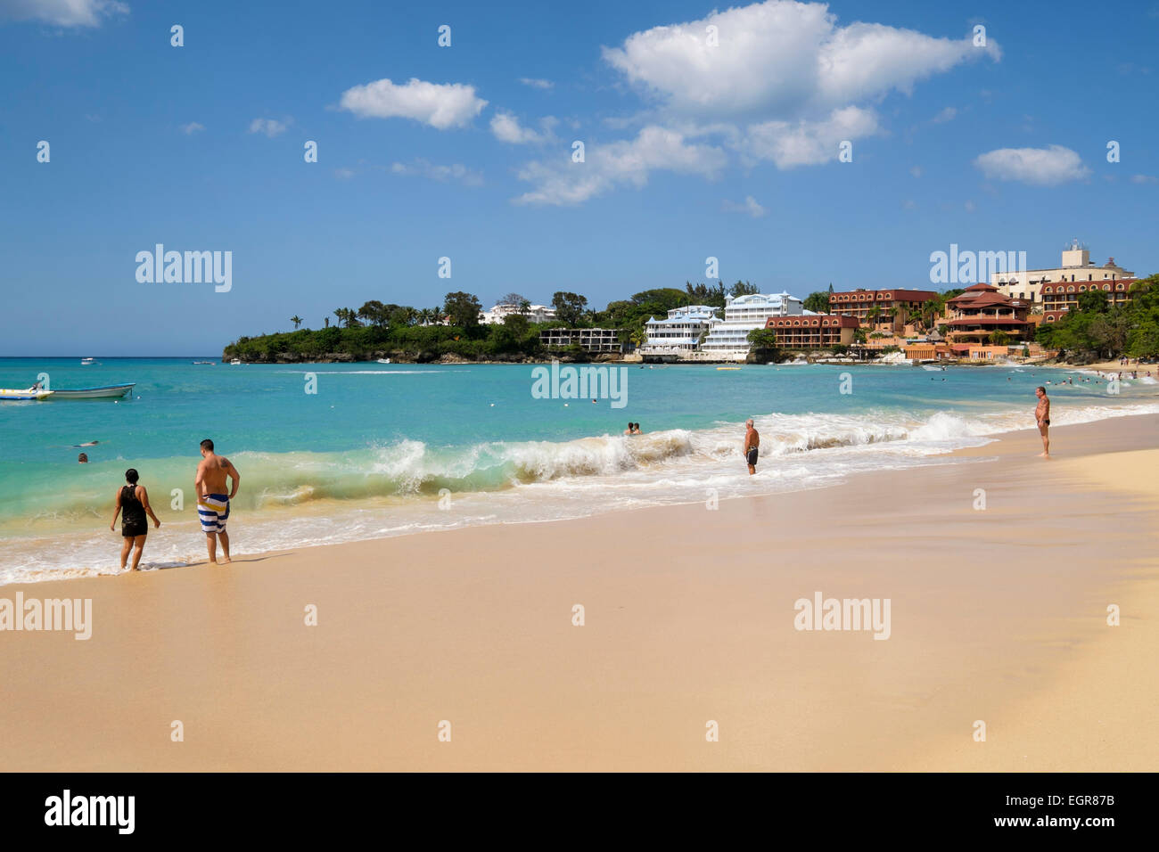 Touristen an einem Sandstrand am Atlantik im Ferienort Sosua, Dominikanische Republik, Karibik Stockfoto