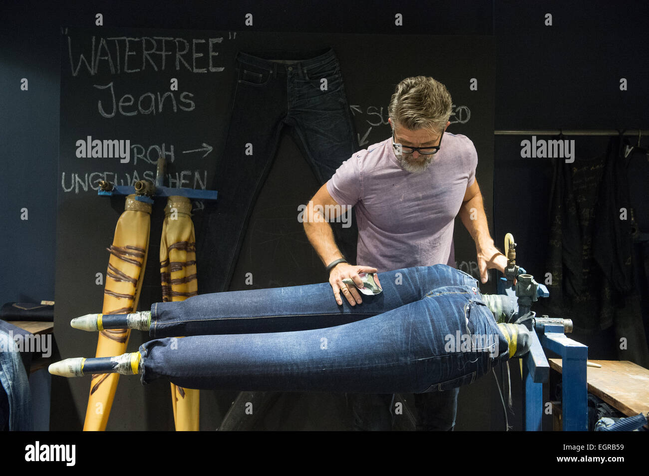 Künzelsau, Deutschland. 26. Februar 2015. Jeans Hersteller Mustang, Guido  Wetzels, Mitarbeiter arbeiten auf stonewashed Jeans Hose bei der Firma  Hauptsitz und Hauptproduktionsstandort site in Künzelsau, Deutschland, 26.  Februar 2015. Foto: Marijan ...