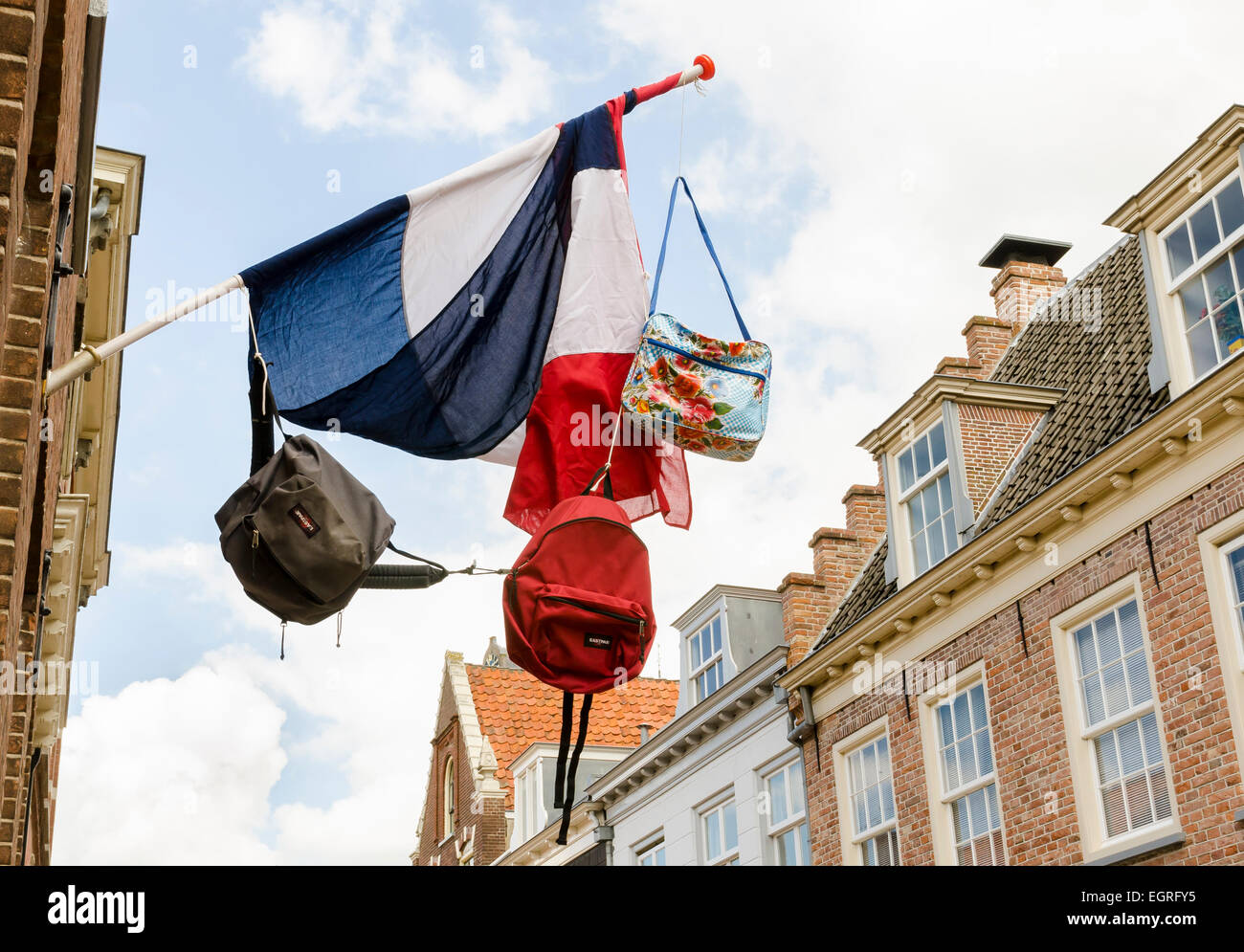 Niederländische Flagge mit drei Taschen drauf und im Hintergrund alte Häuser der Stadt von Wijk Bij Duurstede. Stockfoto