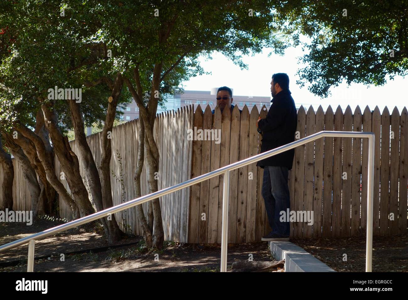 Zwei Männer stehen bei den Lattenzaun auf dem Grashügel. Dealey Plaza in Dallas, Texas. Stockfoto