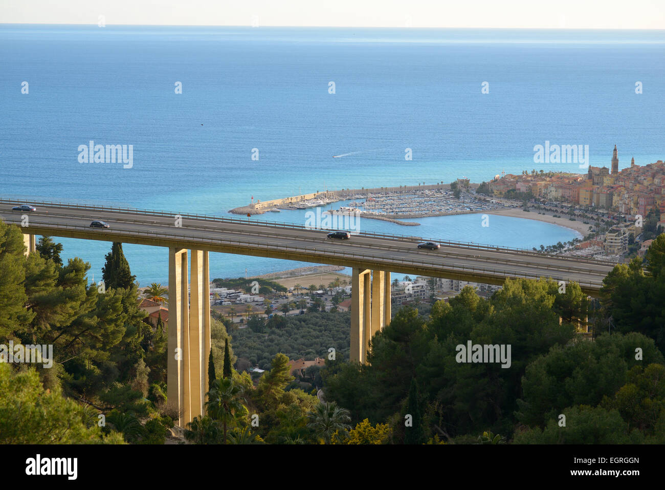 Autos auf einer Autobahnbrücke mit Blick auf die malerische Altstadt von Menton. Alpes-Maritimes, Französische Riviera, Frankreich. Stockfoto