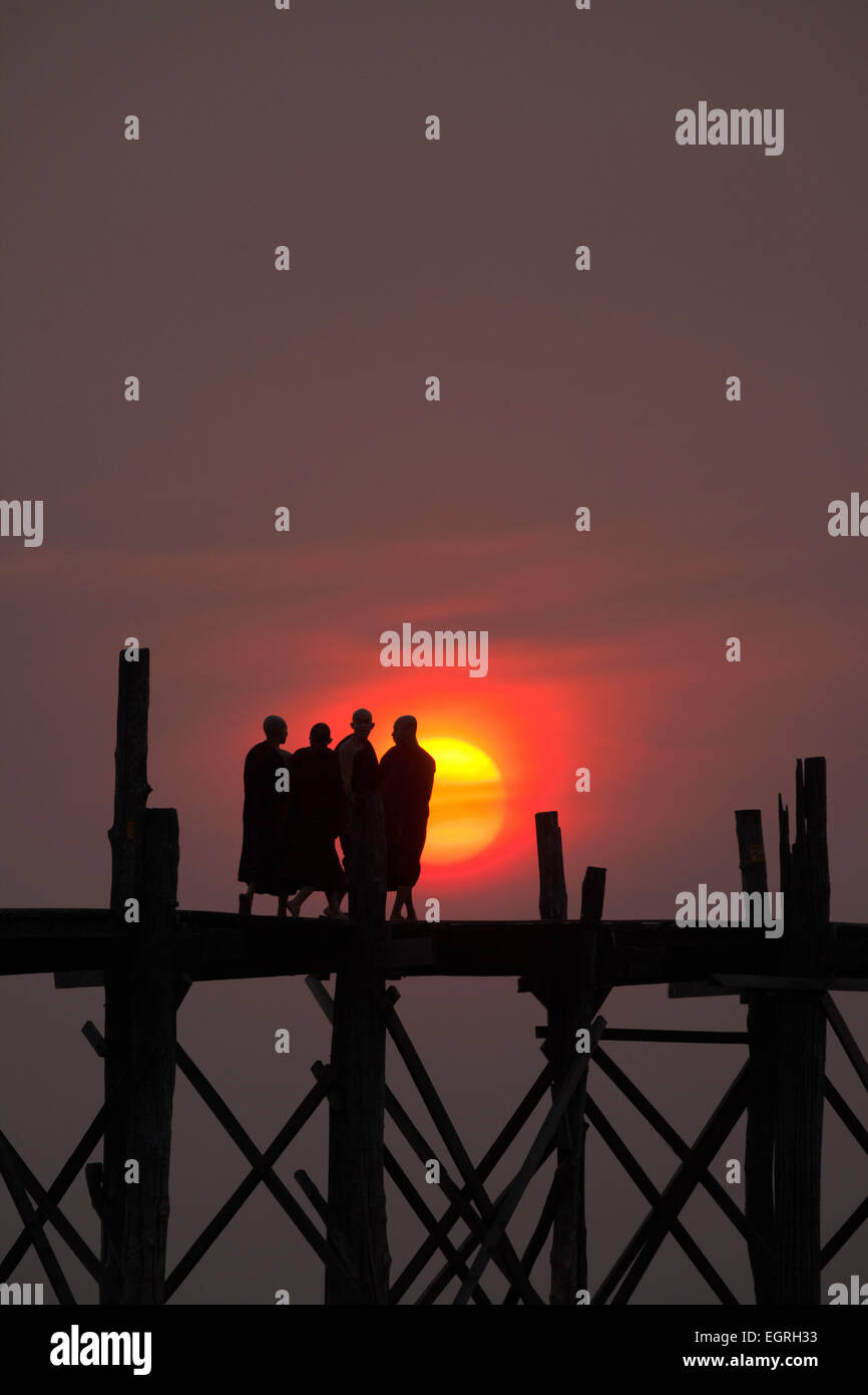 Vier Mönche stehend auf die U Bein Brücke bei Sonnenuntergang, Myanmar (Burma), Asien Stockfoto