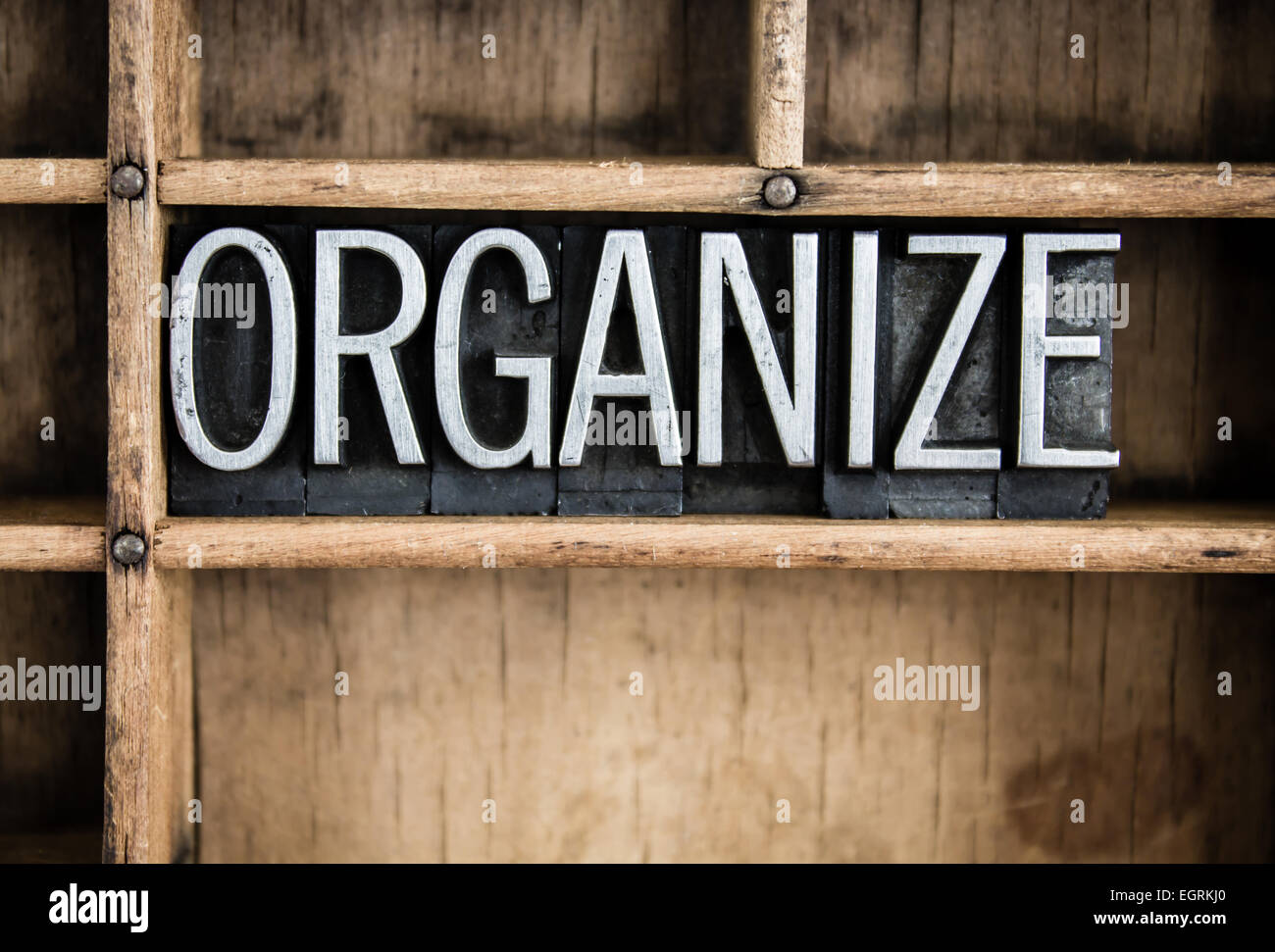 Das Wort "Organisieren" in Vintage Metall Buchdruck Typ in einer Holzschublade mit Teilern geschrieben. Stockfoto