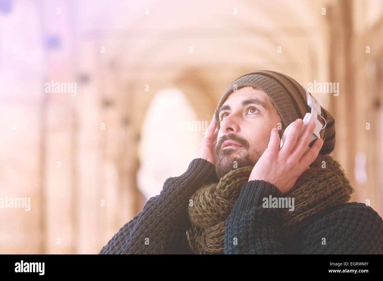 junge stilvolle bärtiger Mann anhören von Musik in einer mediterranen Stadt in Instagram Töne Stockfoto