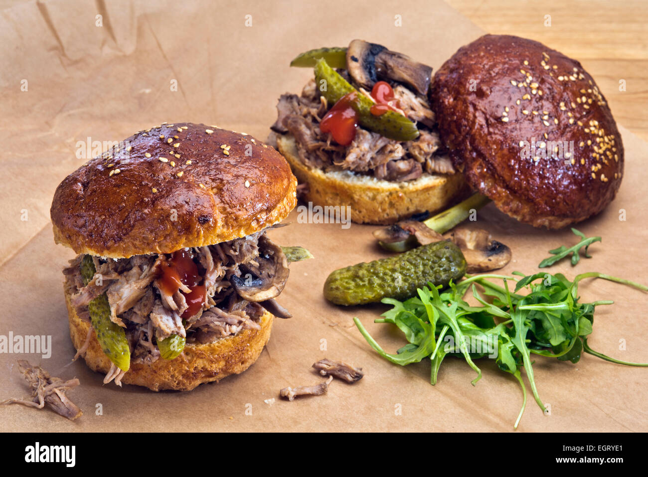 Zwei Sandwiches mit zog Schweinefleisch, eingelegtes Gemüse und gegrillten Pilzen in hausgemachtem Brioche Brötchen. Stockfoto