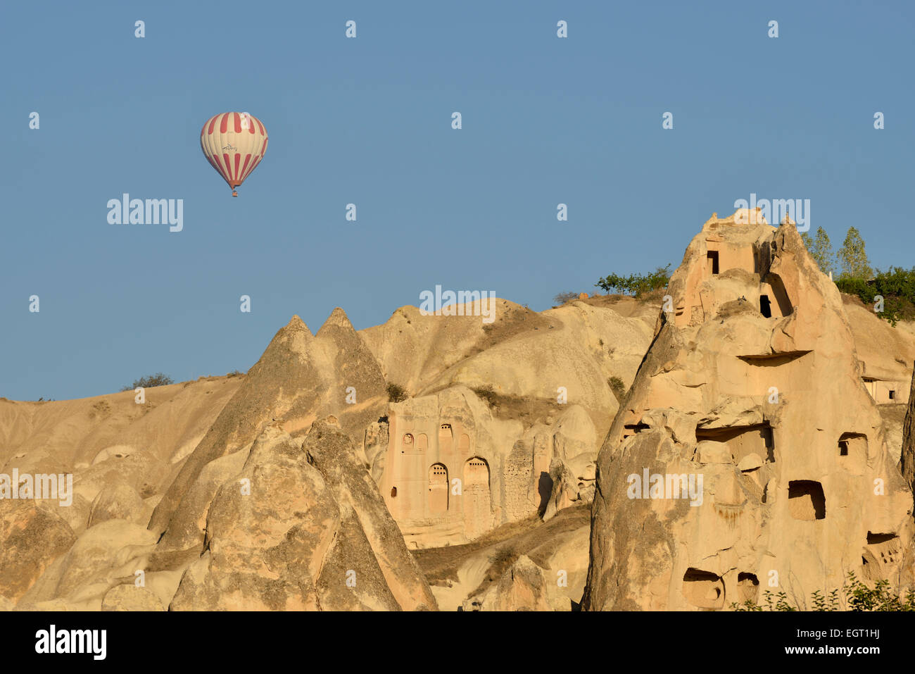 Heißluftballon fliegen über Tuffstein Felsformationen und uralte Höhle Wohnungen, Göreme, Kappadokien, Türkei Stockfoto