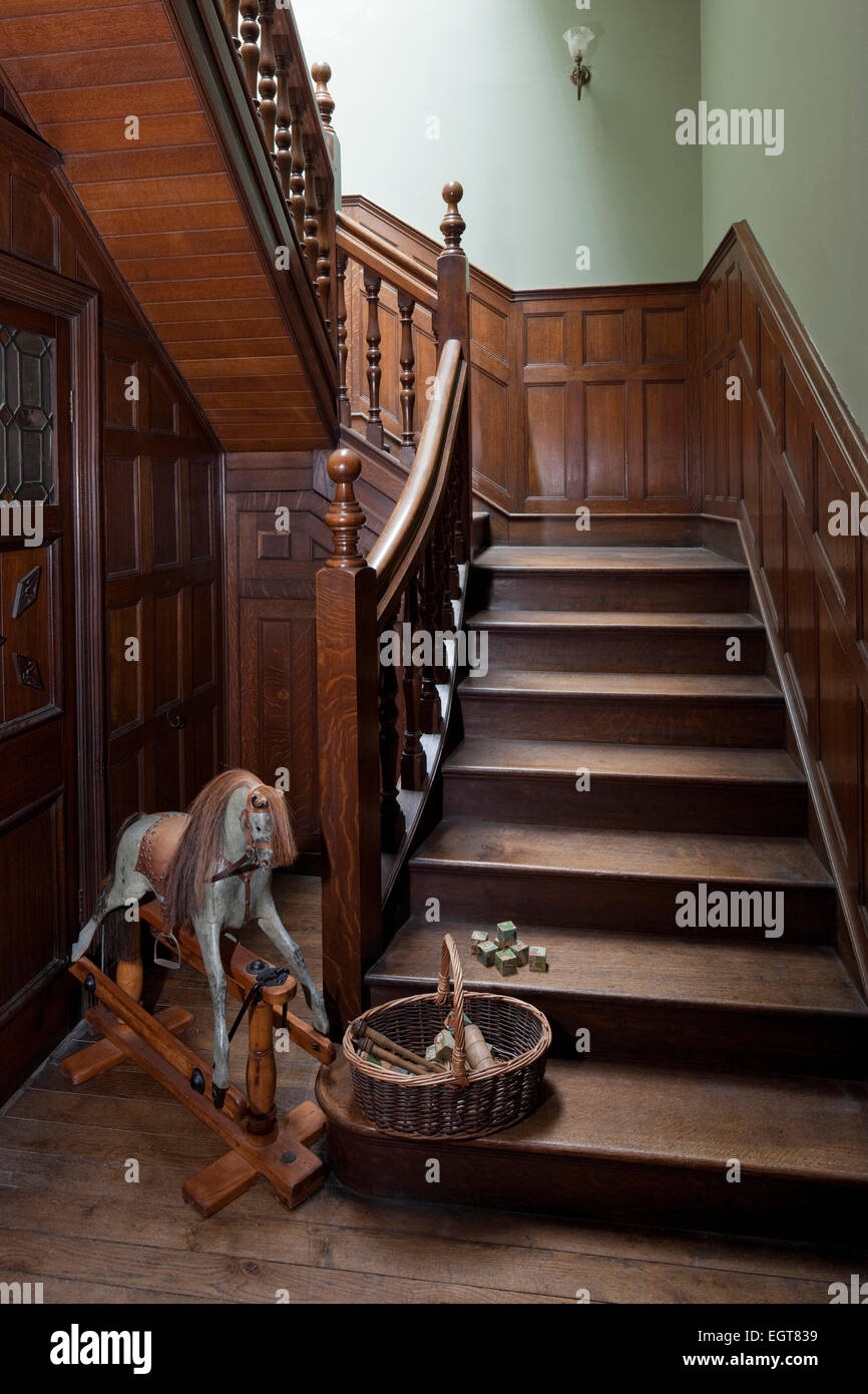 Rocking Horse und Korb auf Kindergarten-Holztreppen in Newstead Abbey, Nottinghamshire, England, UK Stockfoto