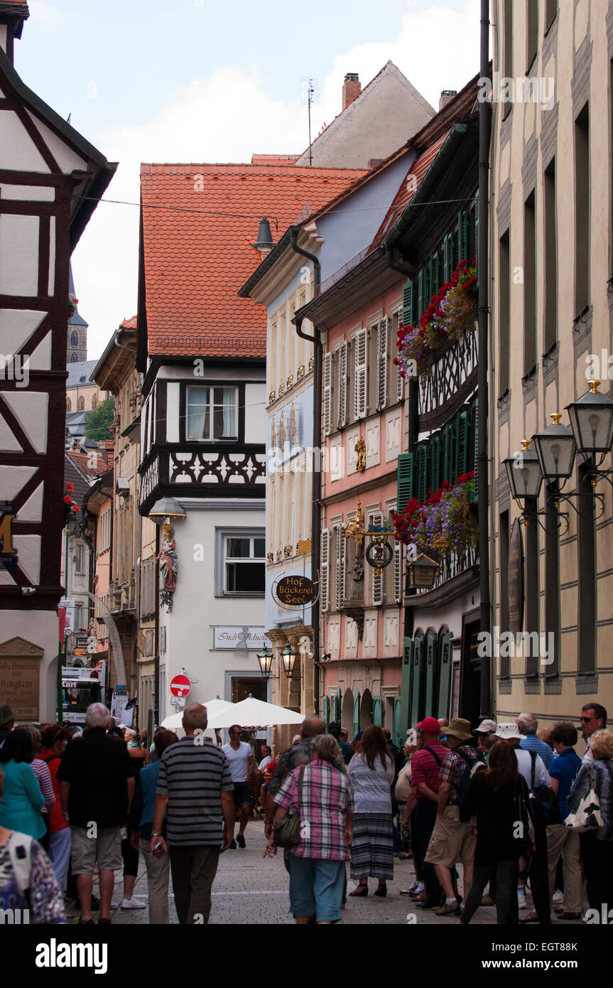 Touristen gehen unter den mittelalterlichen Gebäuden in der zum UNESCO-Weltkulturerbe Bamberg. Stockfoto