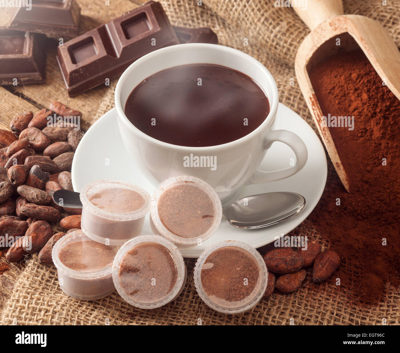 Tasse heiße Schokolade mit Hülsen, Kakaopulver, Kakaobohnen und Schokolade. Stockfoto