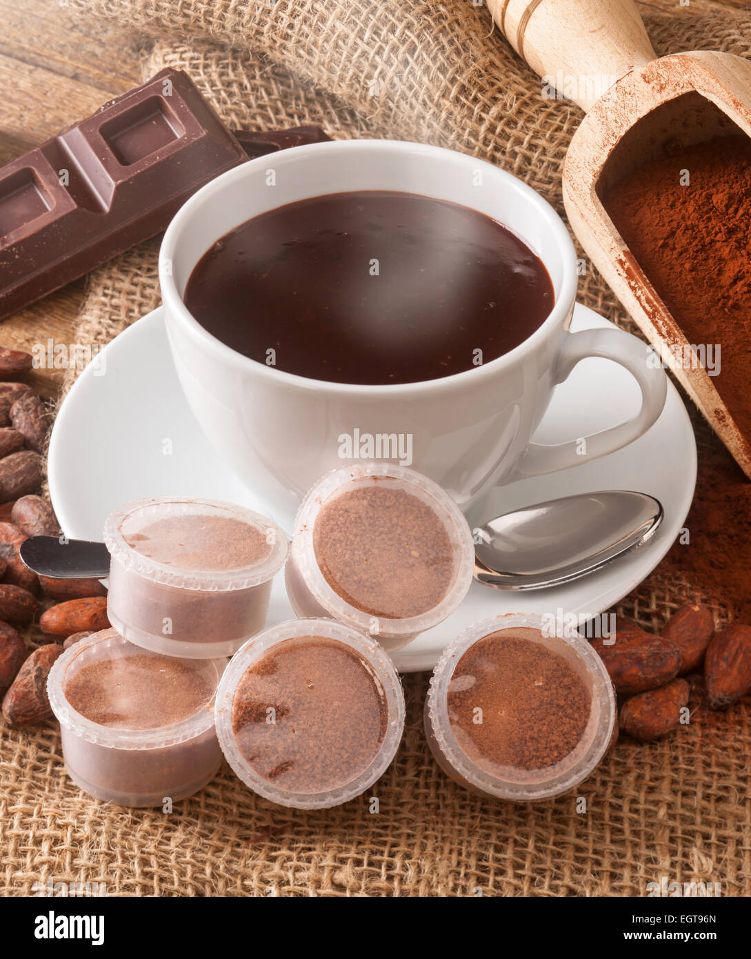 Tasse heiße Schokolade mit Hülsen, Kakaopulver, Kakaobohnen und Schokolade. Stockfoto