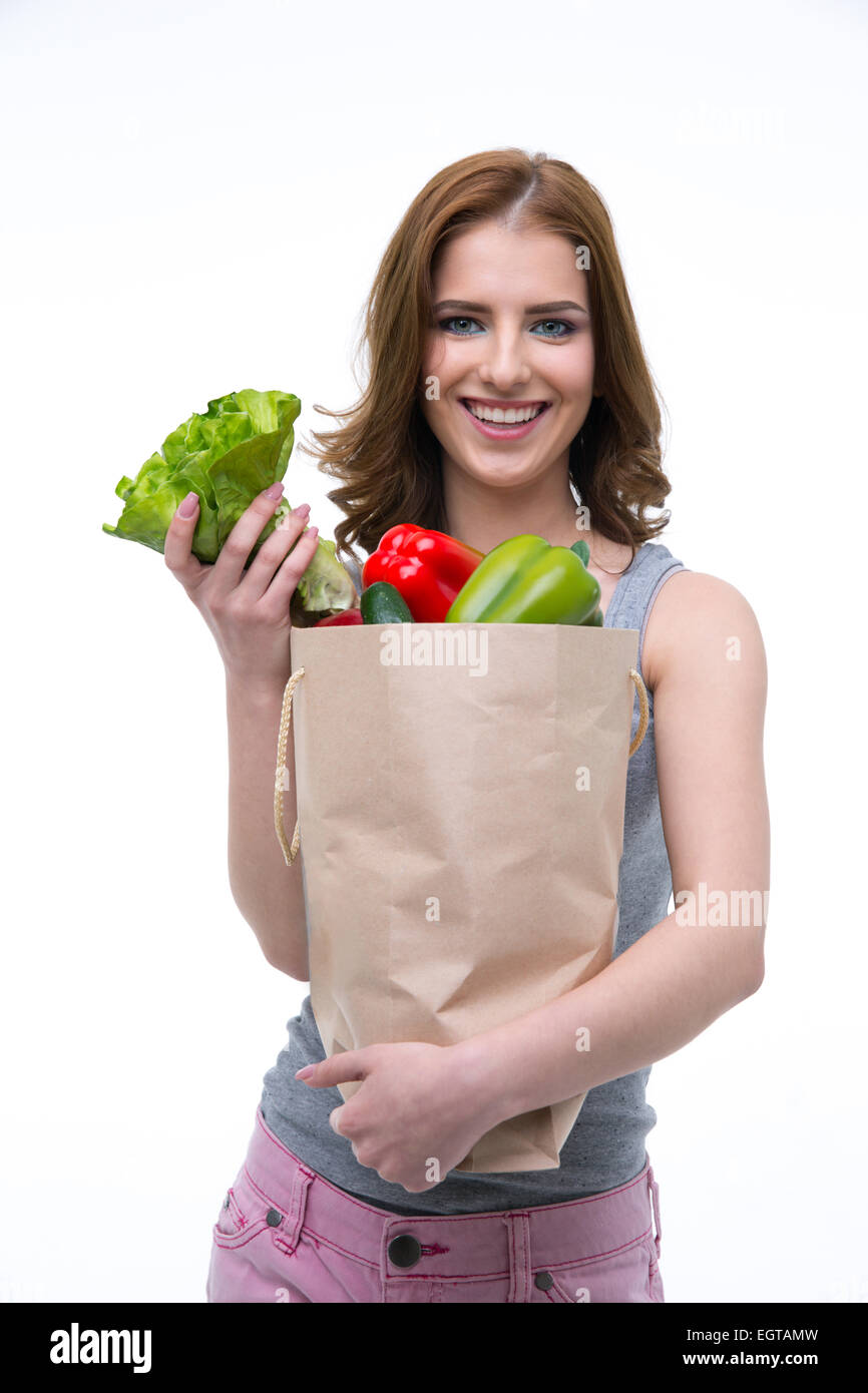 Lächelnde junge Frau hält eine Einkaufstasche voller Lebensmittel Stockfoto